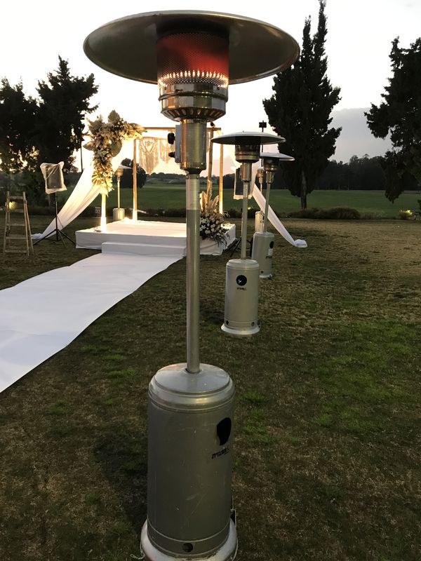 פטריית חימום גז דולקת מוצבת לצד חופה באירוע חתונה בערב.